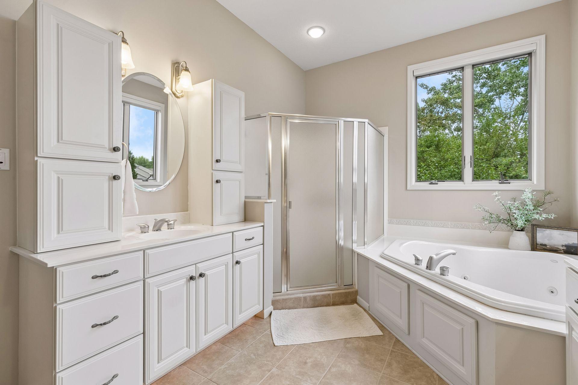 Primary bathroom with dual vanities, shower and soaking tub