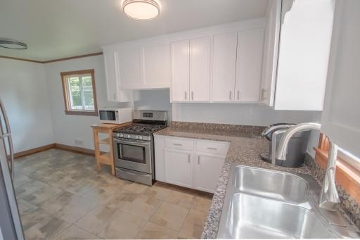 Updated eat-in cooks kitchen with granite tops, enameled cabinetry, and stainless appliances