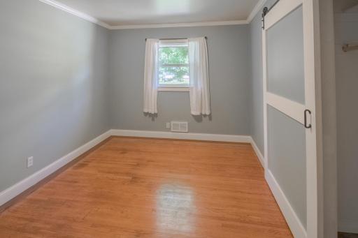 1st of 4 main floor bedrooms - all have pristine hardwood floors and custom barn door closet doors
