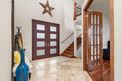 Your main floor features 10 ft ceilings and 8ft doors into two grand junior en suites, guest bath, laundry, and executive office. - Stairway to top floor primary suite. Executive office to the right.