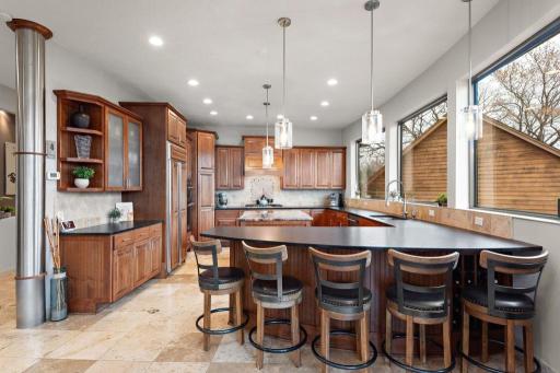 Luxurious leather-textured granite countertops, adding rich depth and sophistication to the gourmet kitchen. Next level 20 bottle wine storage conveniently sculpted into the breakfast bar for 5.