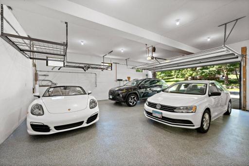 The garage is massive! West facing transom windows welcome natural light into this 756 SQ ft finished sanctuary -Epoxy floor, heated, wired for TV, hardwired for EV Charging station. The new steel garage door dressed in "full-length sidelite windows!