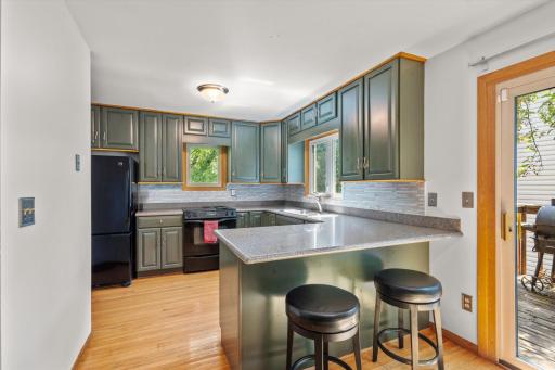 Spacious kitchen with windows and beautiful backsplash.