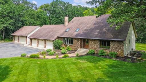 Stunning front view showcasing the home's brick façade, mature landscaping, and inviting covered entry.