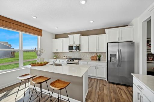 (Photo of model home, finishes will vary) Enjoy plenty of seating at the kitchen island and dining area adjacent to the kitchen. Perfect for entertaining or having a family meal together.
