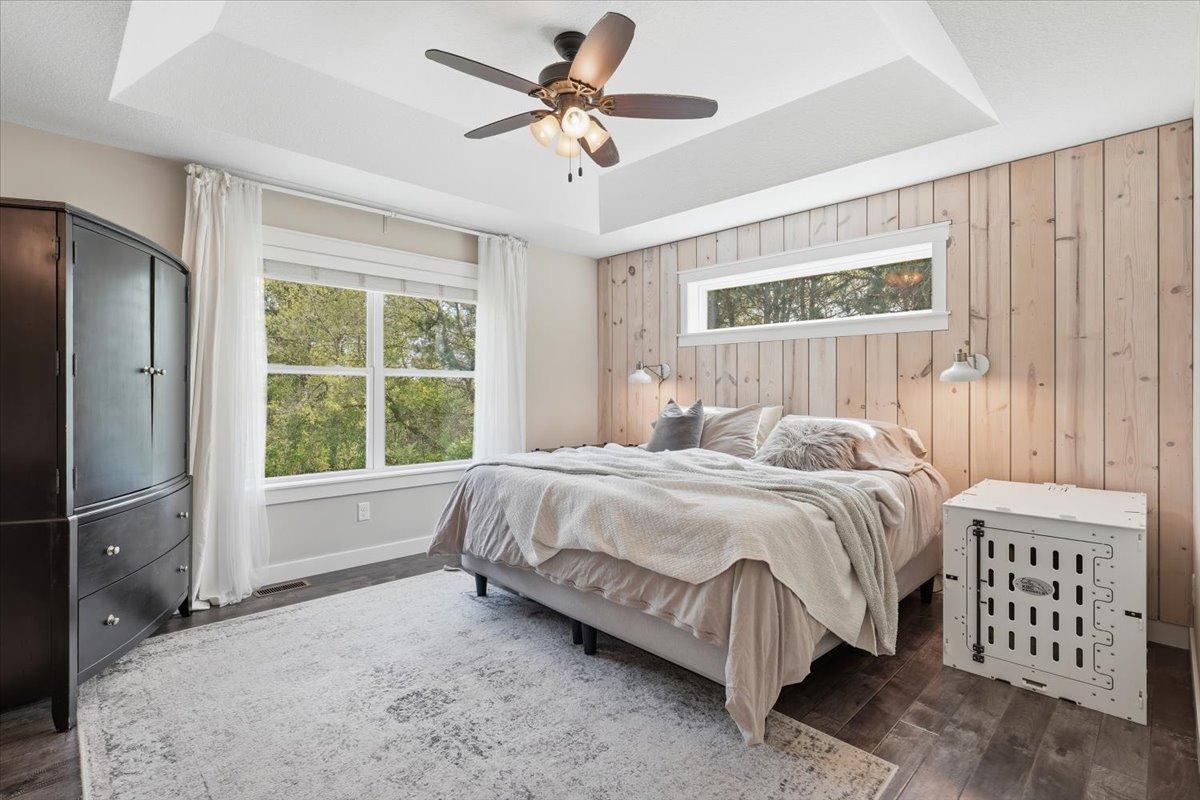 The primary suite is spacious, but also warm and cozy. Raised ceilings make this room feel grand and the privacy out the windows is exactly what you'd desire