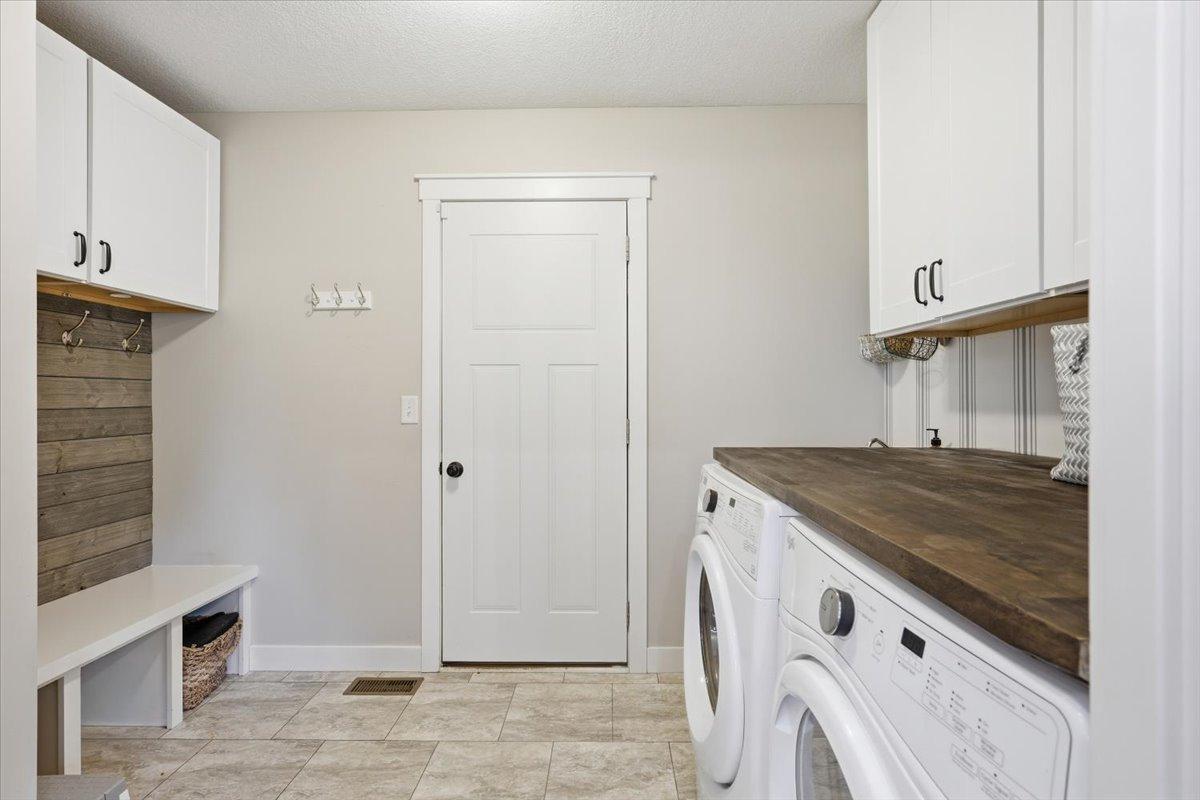 Large mudroom with main floor laundry, closets, cupboards and more all await you as you enter from the garage.