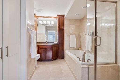 The private primary bathroom features both a soaking tub and walk-in shower and classic tile floors.