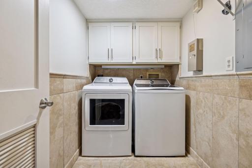 Private in unit laundry featuring newer washer and dryer and cabinets.