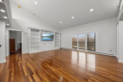 The living room with full wall built-ins and access to the screened porch.