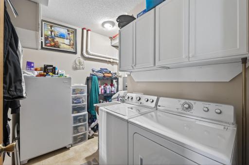 This laundry room is spacious and provides additional storage.