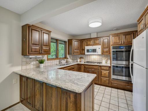 The spacious kitchen has granite counters, stunning cherry cabinets and rare double ovens!!