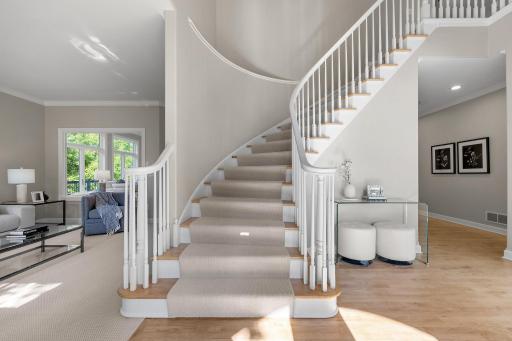 As you step into the foyer, you're welcomed by soaring 18-foot ceilings, beautifully refinished hardwood floors, a grand staircase that makes a stunning first impression, and ample storage, including two spacious walk-in closets.
