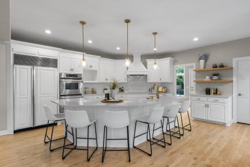 The fully remodeled kitchen showcases custom cabinetry and a panel-front Sub-Zero refrigerator that blends seamlessly with the surrounding cabinetry for a clean, built-in look.