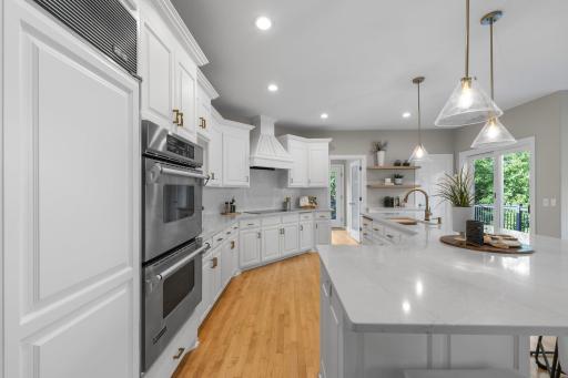 High-end appliances include a JennAir double wall oven and a Bosch dishwasher, all complemented by expansive quartz countertops and a generous center island with breakfast bar seating.