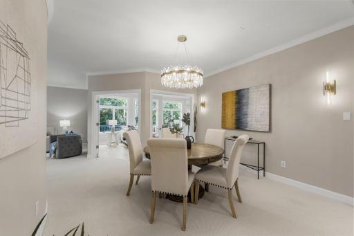 The formal dining room on the main level impresses with a striking chandelier, brand-new plush carpeting, and a well-appointed wet bar featuring elegant cabinetry and a built-in wine rack.