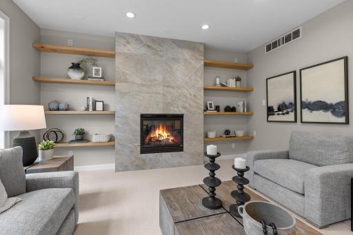 The main-level family room offers the perfect space to relax and unwind, featuring a cozy gas fireplace with a stylish stone surround, brand-new plush carpeting, and wood shelvingâideal for storage or displaying your favorite dÃ©cor.