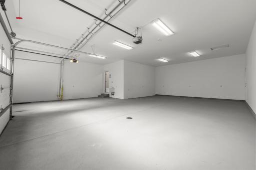 The impressive 5-car attached tandem garage boasts freshly painted floors and provides ample room for vehicles, storage, and hobbies, offering both functionality and flexibility for modern living.