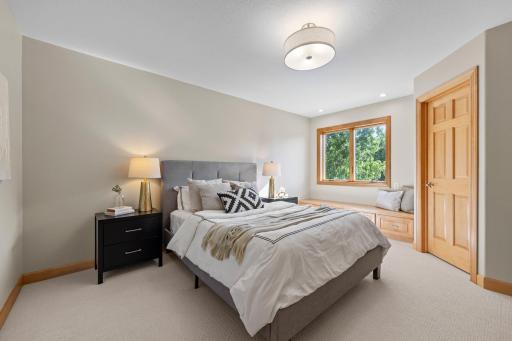 Also on the upper level, Bedroom Three mirrors Bedroom Two with a walk-in closet, bay window with bench seating, plush carpeting, and front yard views. They share a Jack-and-Jill bathroom featuring private vanities and a shared tub-shower combo.