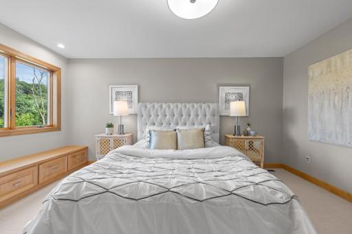 Bedroom four, located on the upper level, features a generous closet and a charming built-in bench beneath a window with serene views of the backyard.