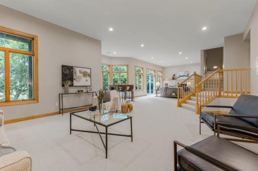 Entertain with ease in the expansive walk-out lower-level family and recreation room, featuring soaring 11-foot ceilings, an abundance of natural light, and a warm gas-burning fireplace with an elegant stone surround.