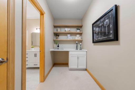 A well-appointed area just outside the second lower-level full bathroom, featuring countertop space, shelving, and cabinetryâperfect for additional storage, dÃ©cor, or a hobby nook.