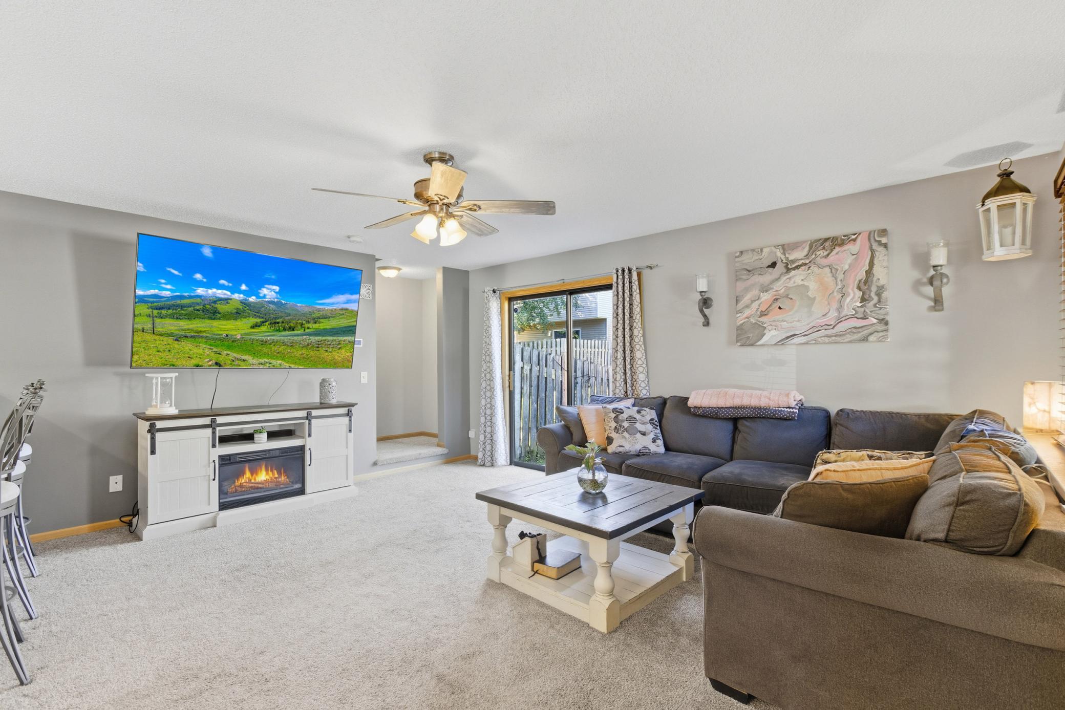Spacious main level living room with patio doors that lead out to the fenced yard.