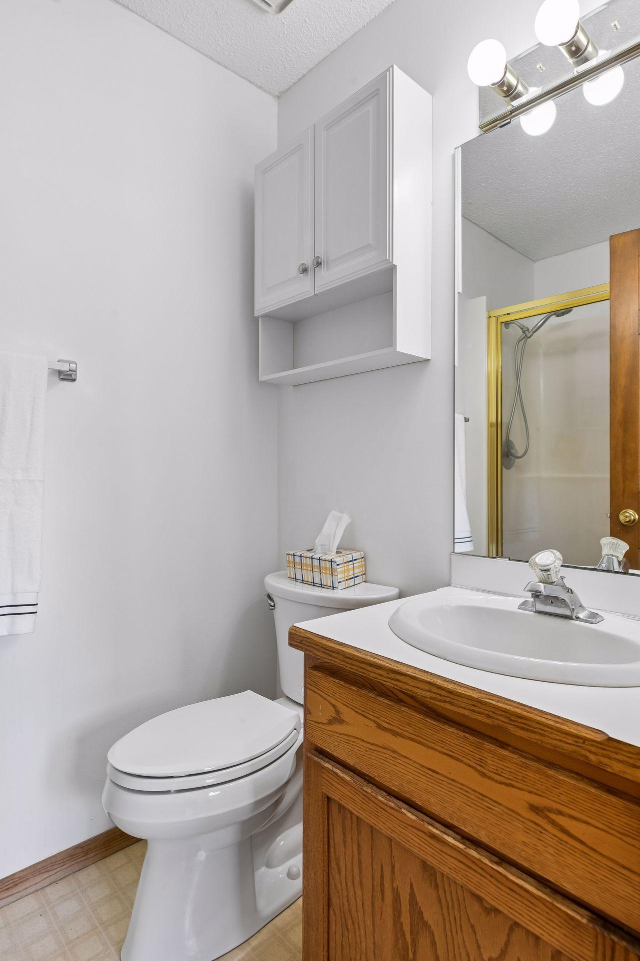 Bath has glass enclosed shower