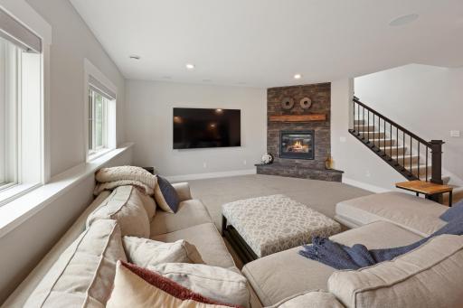 Cozy family room in lower level with a stone gas fireplace