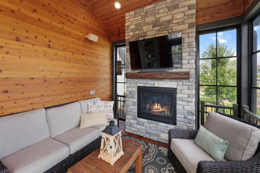 Featuring a stone fireplace and warm wood textures