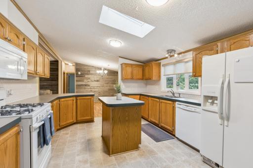 The bright kitchen offers a center island and new backsplash (July 2025)!