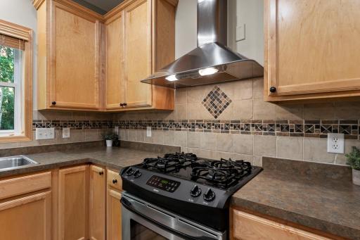 The kitchen includes a tile backsplash and granite countertop on the island.