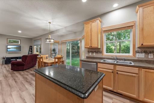 The kitchen includes a tile backsplash and granite countertop on the island.