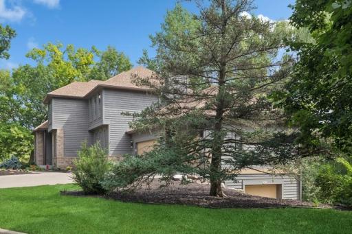 Side view of home with entrance to lower 3 car garage