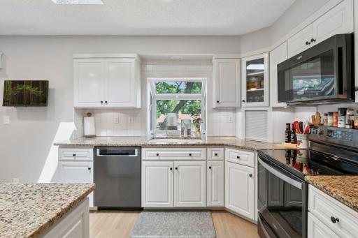 Ample counter space with granite extending into the plant window. Corner appliance "garage" to keep it tidy.