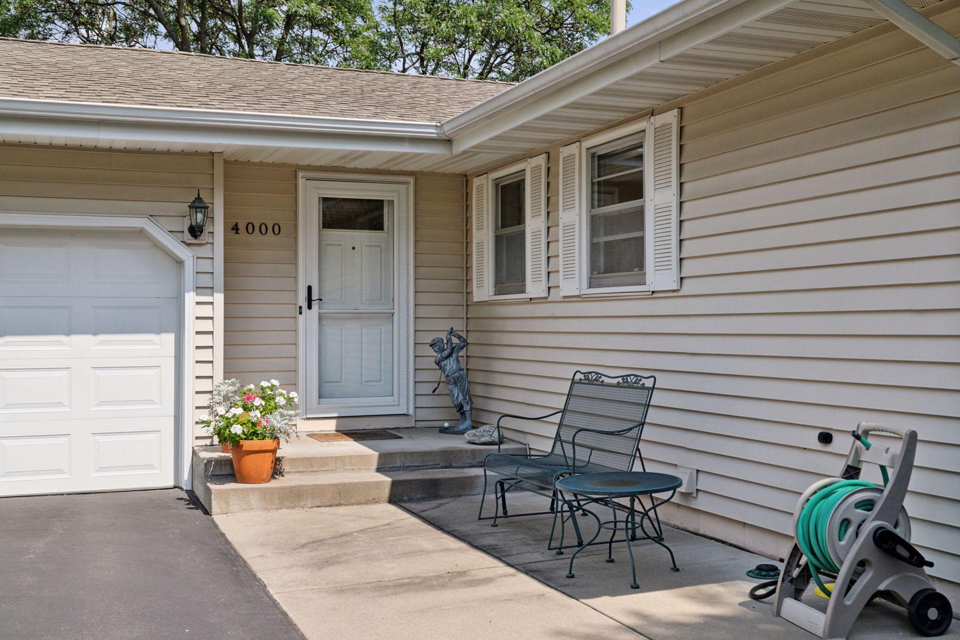 Asphalt driveway with cement steps into home.
