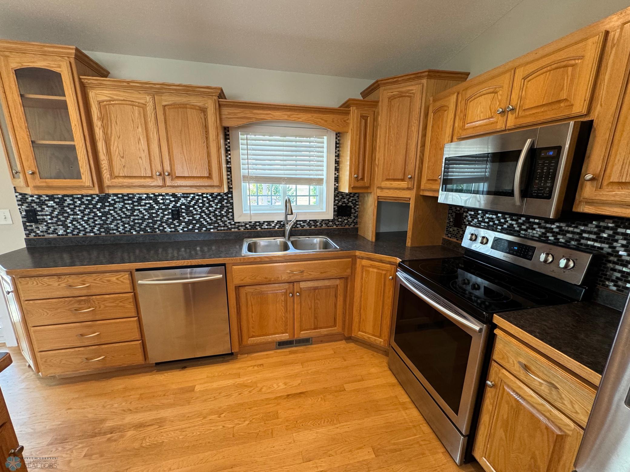 Kitchen with hardwood flooring and stainless steel appliances
