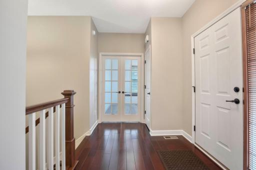 Welcoming entrance includes French doors to a private office, a coat closet, and stair access to the lower level.