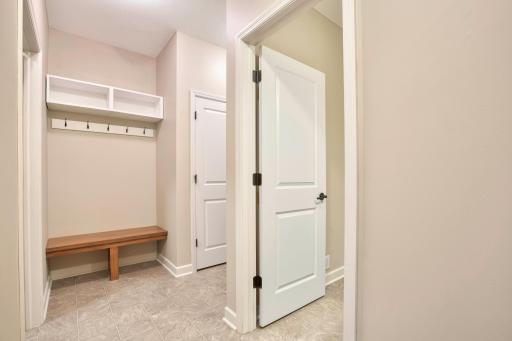 Thoughtfully designed mudroom includes bench seating, wall hooks, and cubbies for daily convenience.