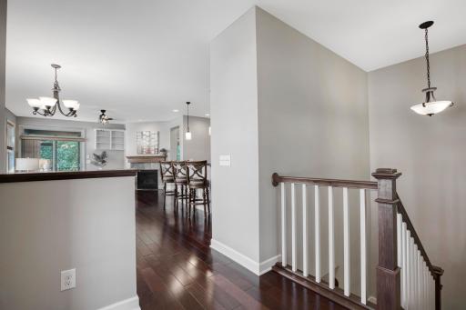 Inviting main level with recessed lighting, rich hardwood flooring, and an open flow into the kitchen, dining, and cozy fireplace-lit living room.