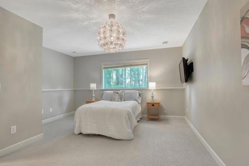 Another angle of the lower-level bedroom with designer chandelier and fresh paint.