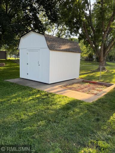 Large well maintained shed on a cement slab with a large sand box