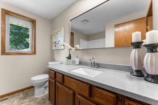 The nearby remodeled full bathroom includes a tub/shower combination, a vanity with extended counter space, and a hallway linen closet for extra storage.