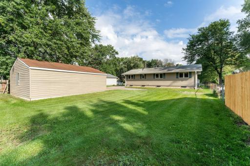Outdoors, the property provides generous space to enjoy and unwind, featuring a large yard shaded with mature trees. The backyard is partially enclosed with both chain-link and wood fencing, creating a comfortable blend of privacy and openness.