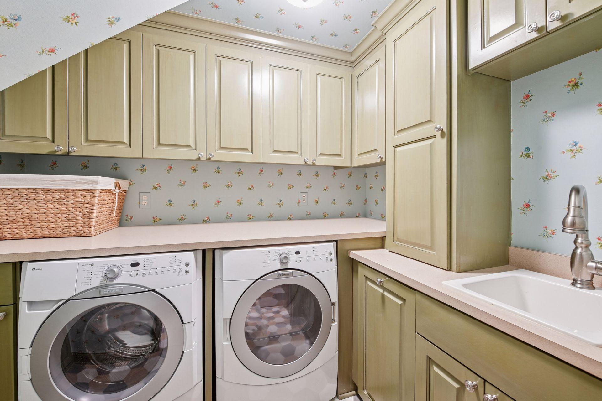 Main floor laundry room with a sink and upper/lower cabinet space