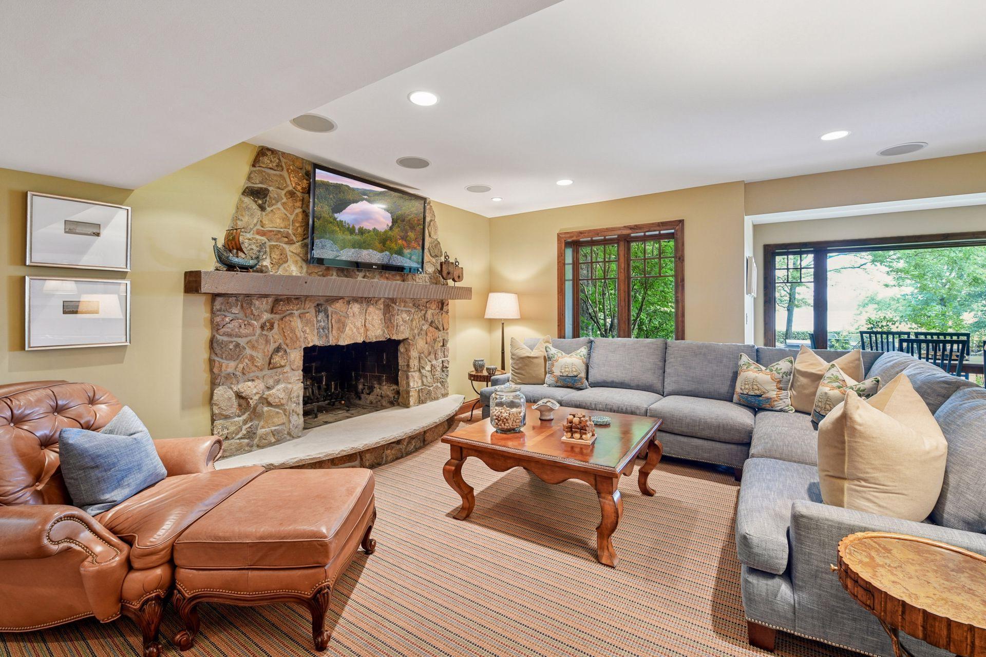 Lower level rec room with stone surround wood burning fireplace