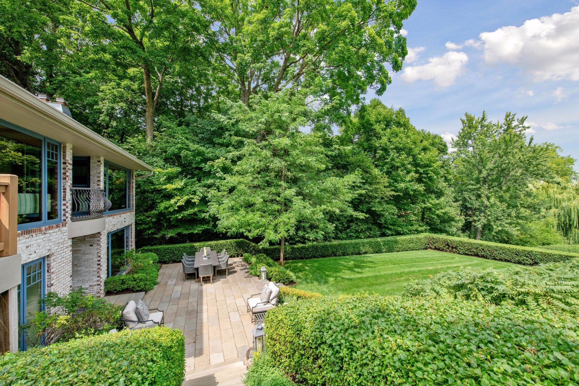 Private backyard retreat featuring a spacious patio, lush landscaping, and mature trees for added privacy
