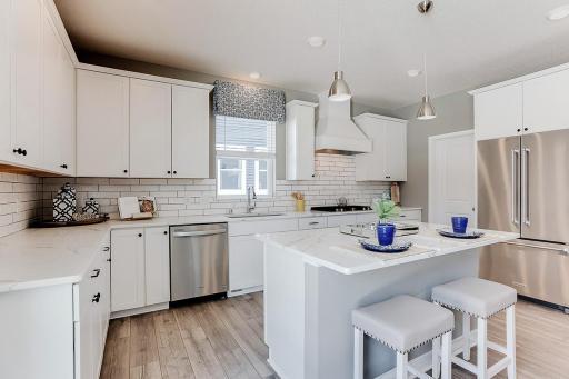 The anchor of the kitchen, the island will be coated with these same Quartz countertops & can serve as a perfect gathering piece for both family night & while entertaining your guests. Photo of model home, color & options may vary.