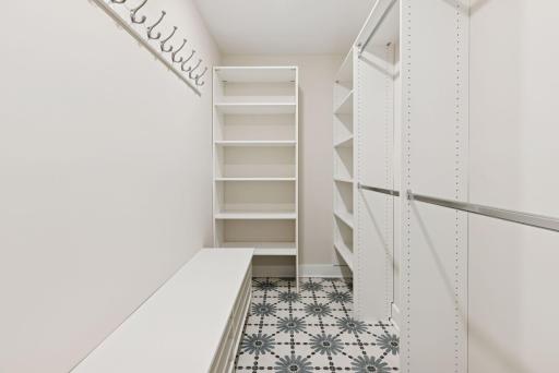 Wonderful new walk-in closet off the laundry room with built-in organizational components and striking floor tiling.
