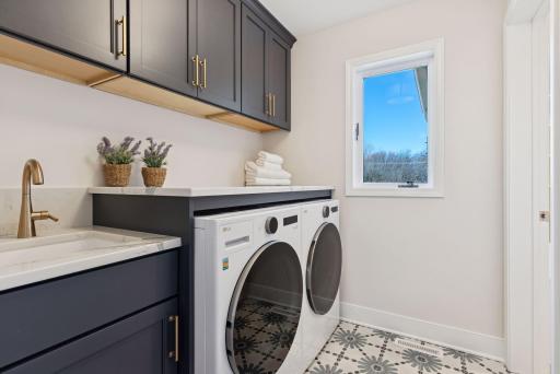 Experience the convenience of the fabulous main floor laundry room, featuring a sink and ample storage space to keep everything organized and efficient.